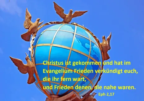 Weltkugel, um die Friedenstauben gruppiert sind vor blauem Himmel.